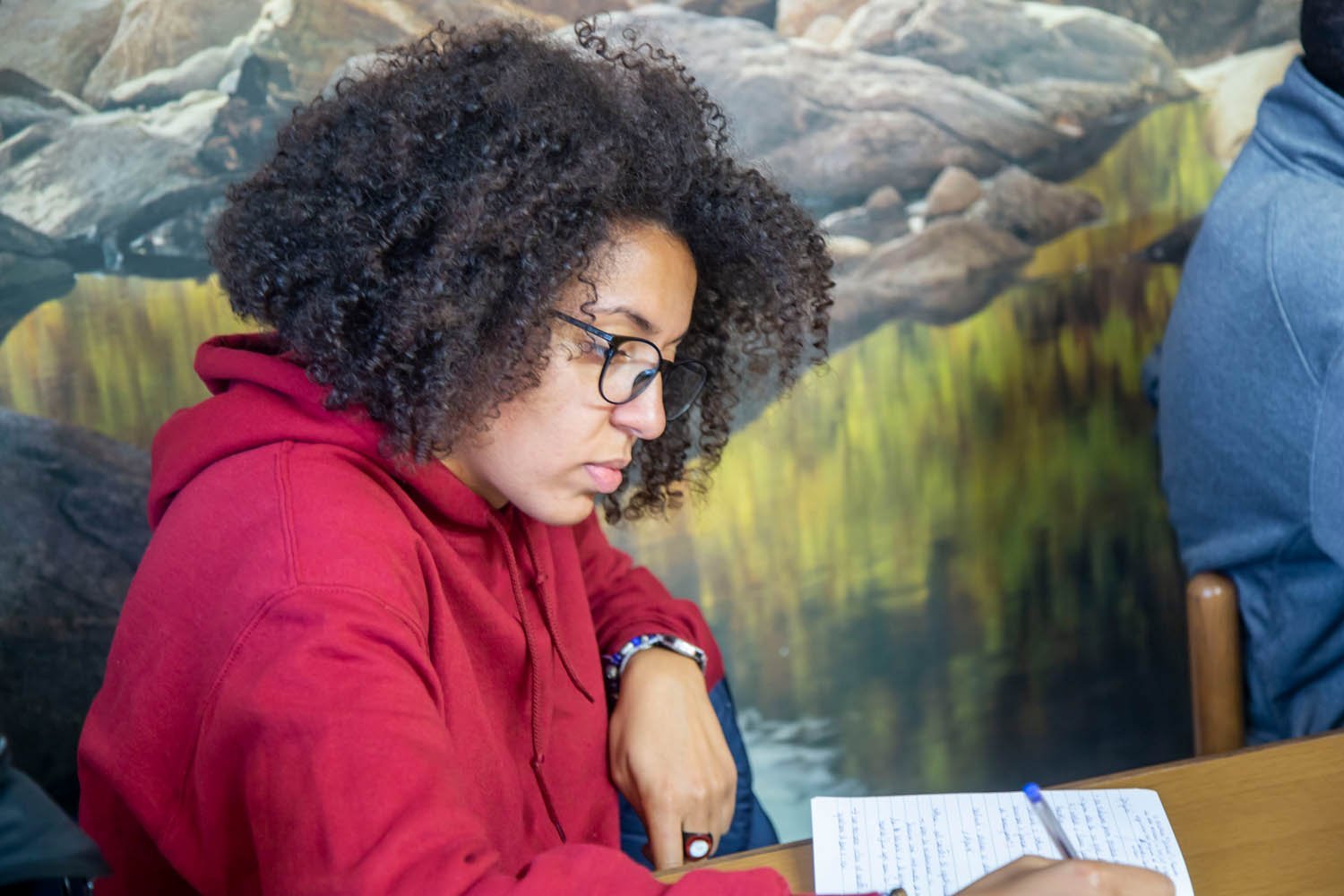A participant taking notes during a Sankofa Political Studies session