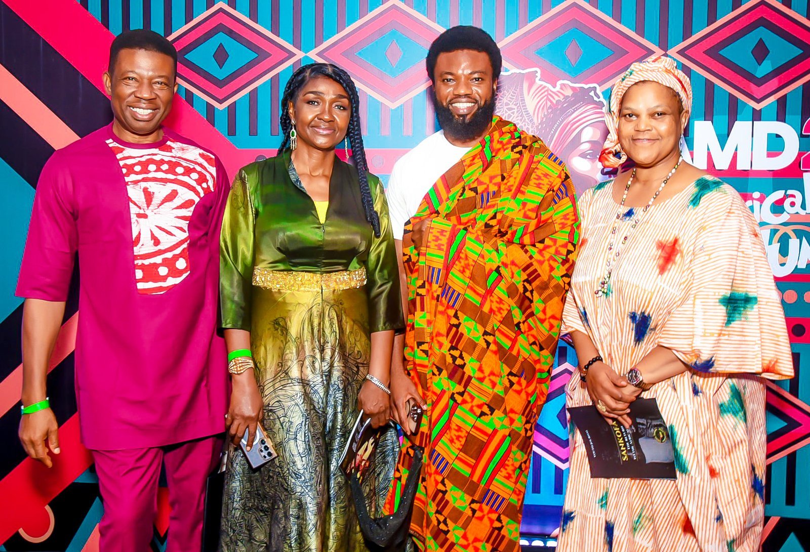 Four guests in African attire in front of the Africa Memorial Day backdrop